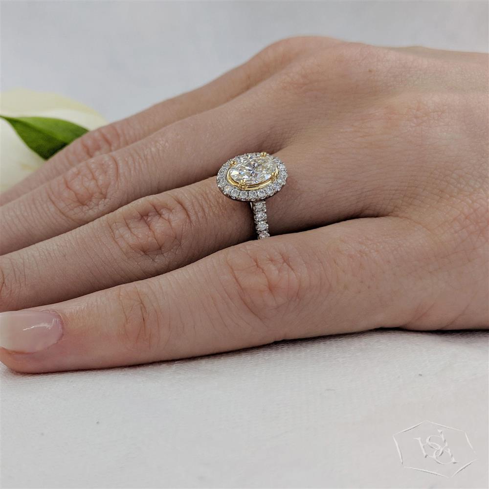 oval cut diamond in a platinum shank and18ct yellow gold head cluster diamond band